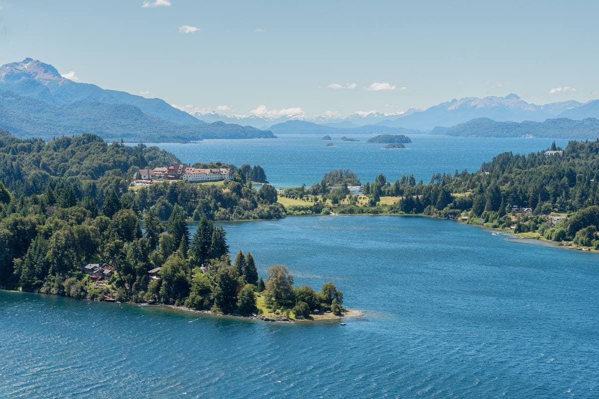 Blue lake water, forested peninsulas and mountains