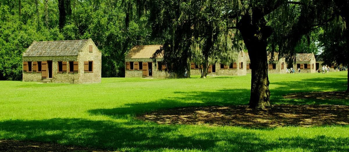 A row of small brick cabins under trees