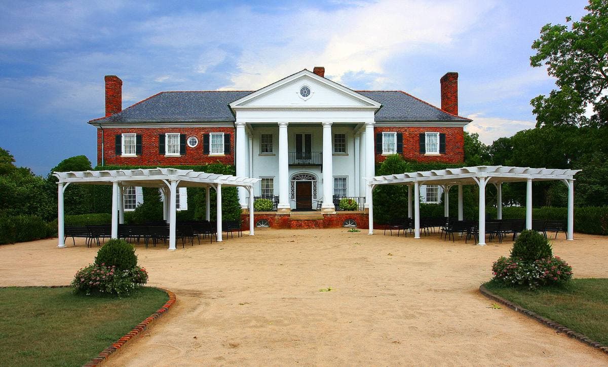 A brick Colonial Revival house with a white columned portico