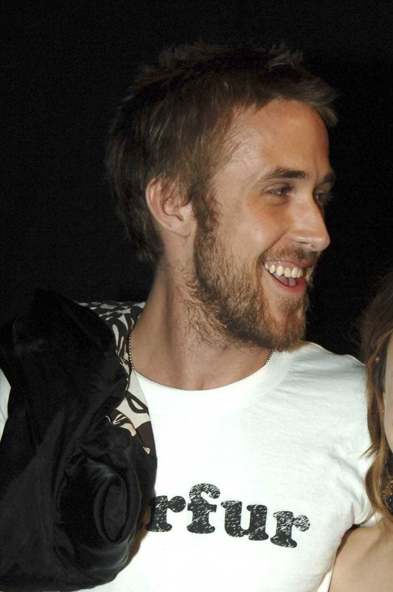 Ryan Gosling, bearded and laughing, in a white T-shirt
