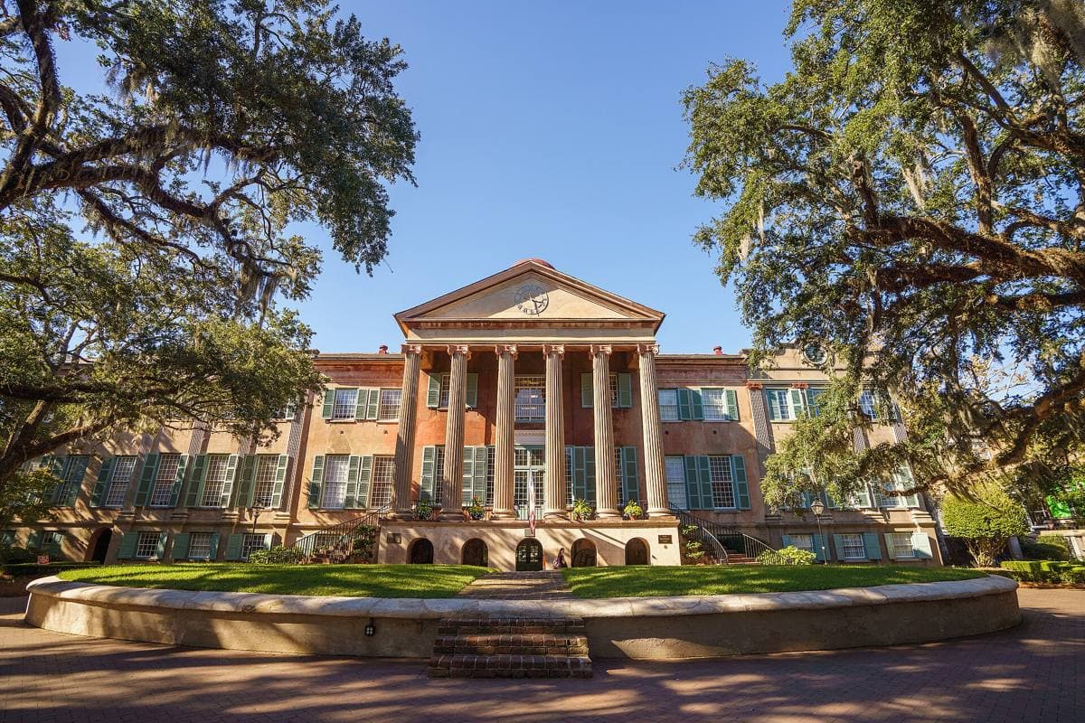 Randolph Hall’s columned portico across a lawn under live oaks