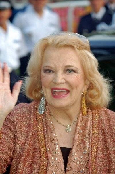 Gena Rowlands, smiling and waving, with blonde hair