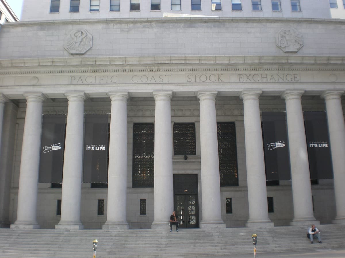 A stone entrance with tall bronze doors on a downtown corner