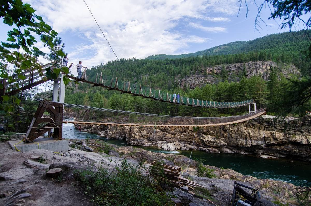 A suspension footbridge across a rocky river gorge