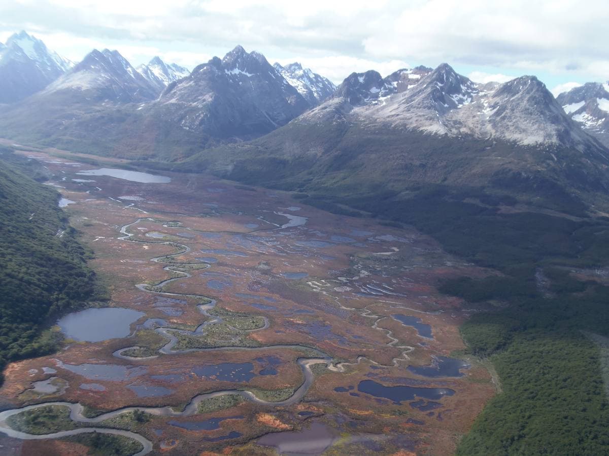 A river winding through a wide valley below jagged peaks in Tierra del Fuego