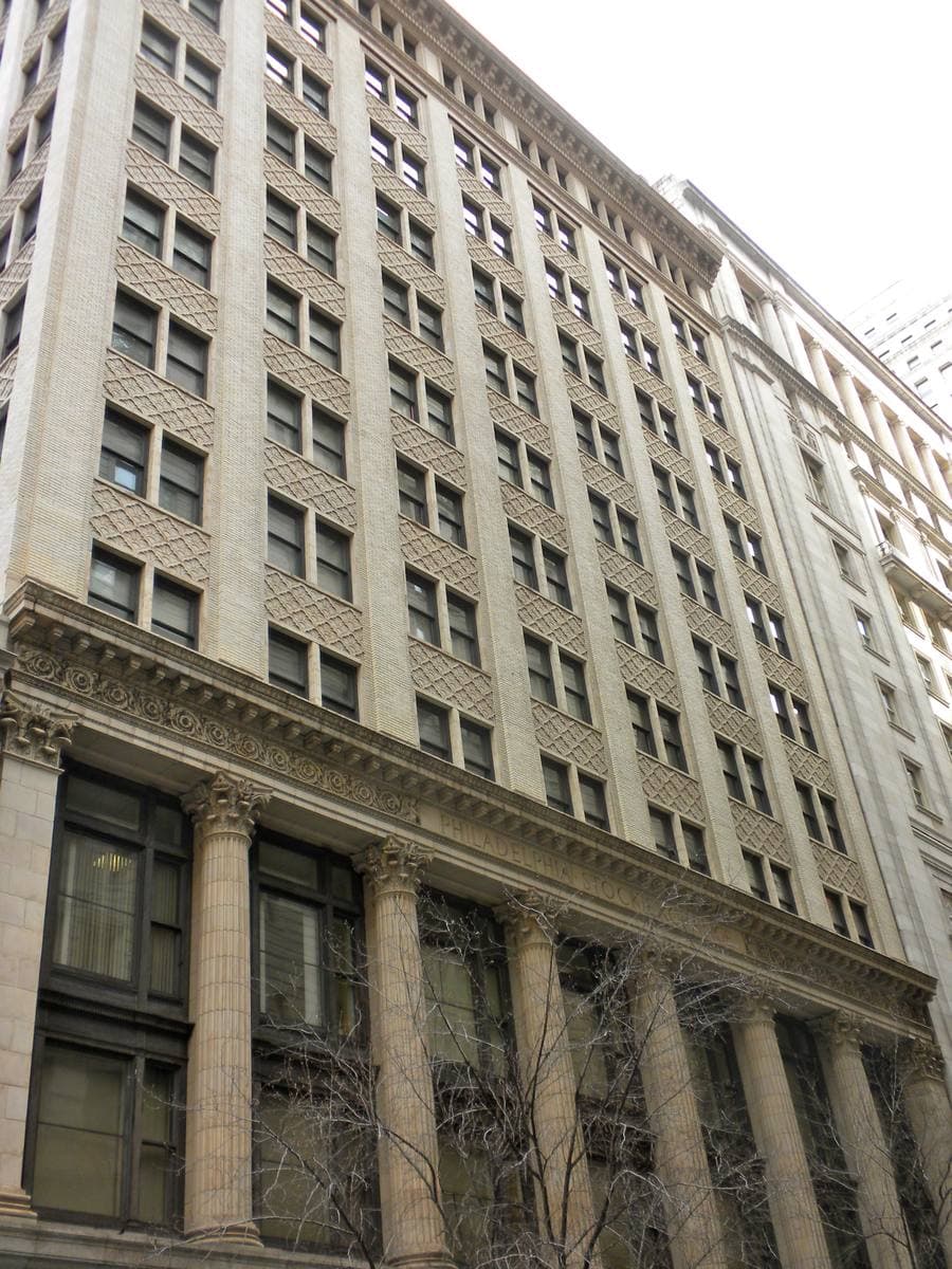 A tall stone-and-brick office front with columns on Walnut Street