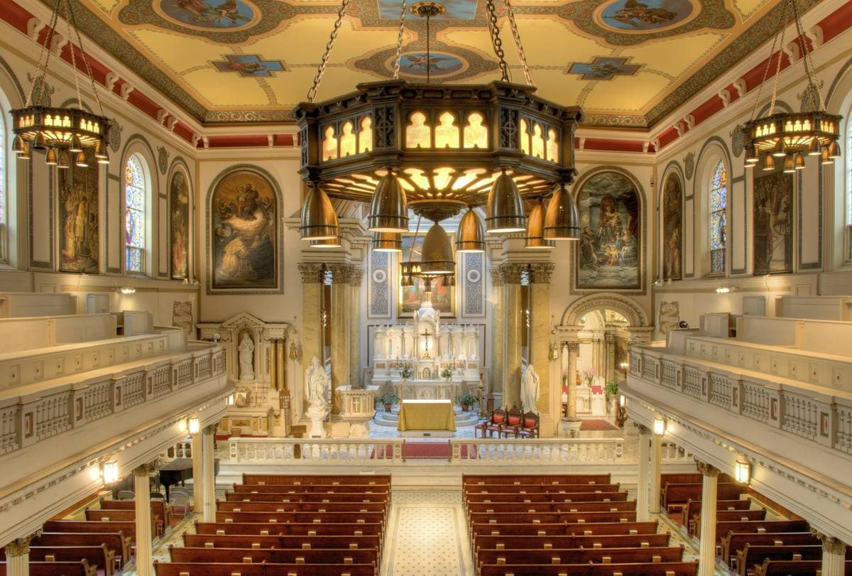 The painted nave of St Augustine’s church, rows of pews leading to a white marble altar