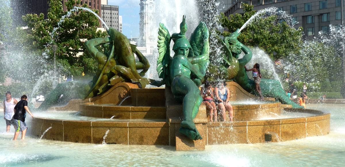 Green bronze figures in the jets of a round fountain