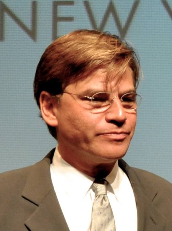Aaron Sorkin in glasses and a grey suit