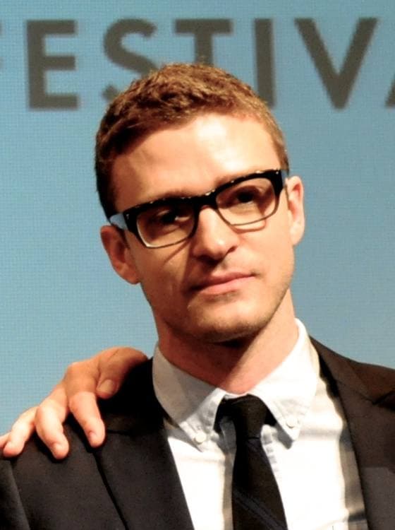 Justin Timberlake in black-framed glasses, a white shirt and dark tie