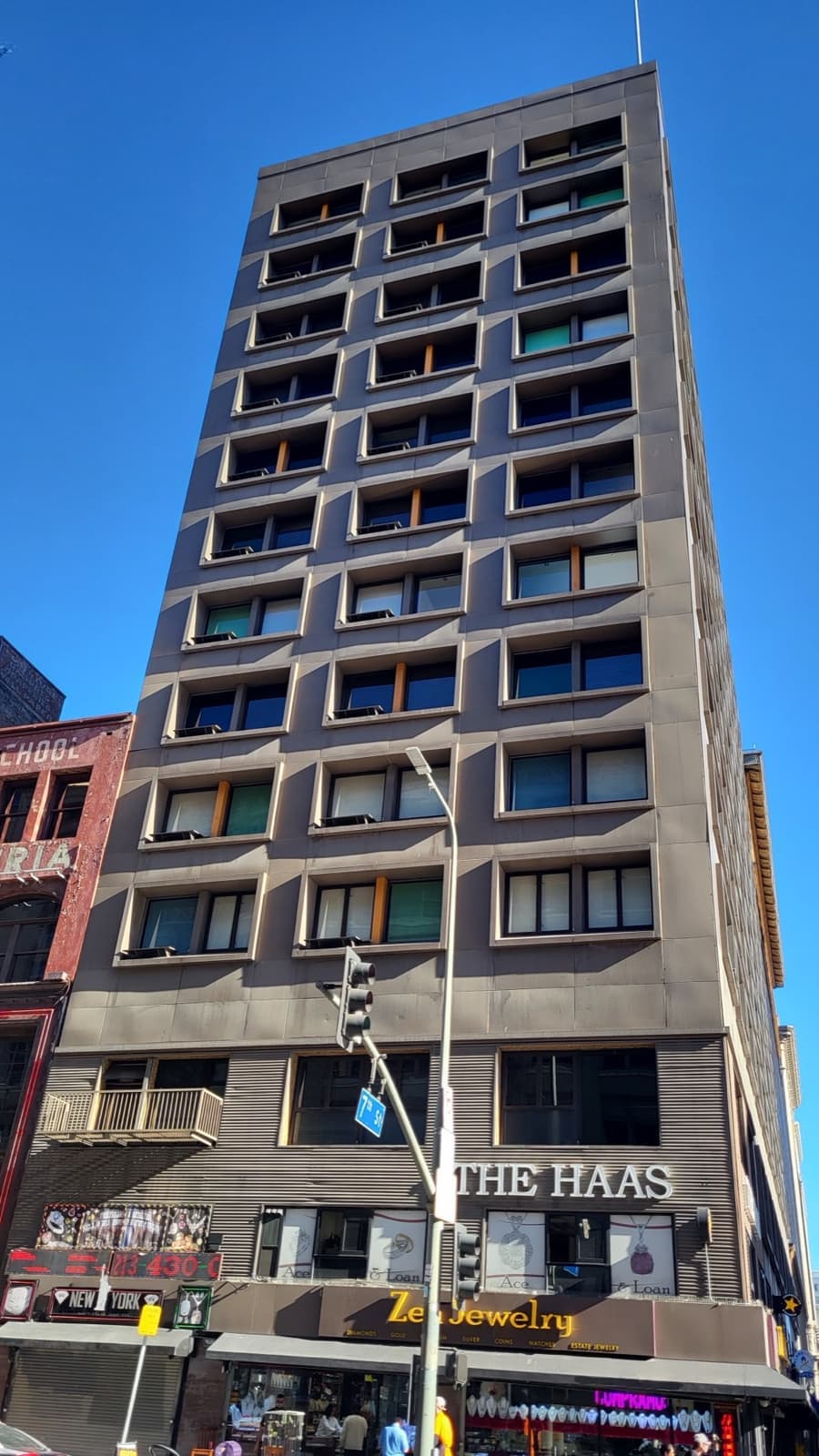 A tall brick office building with a jewellery shop at street level