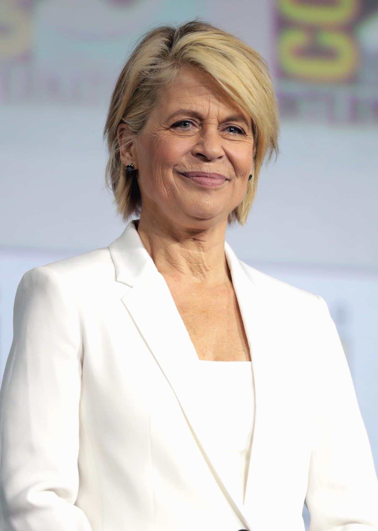 Linda Hamilton in a white jacket, smiling
