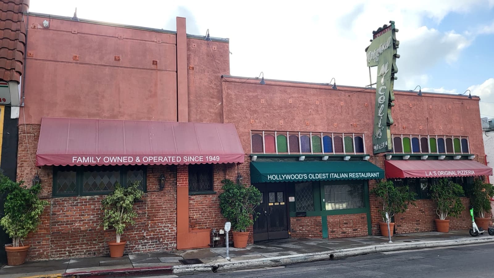 A red-brick Italian restaurant with green and red awnings