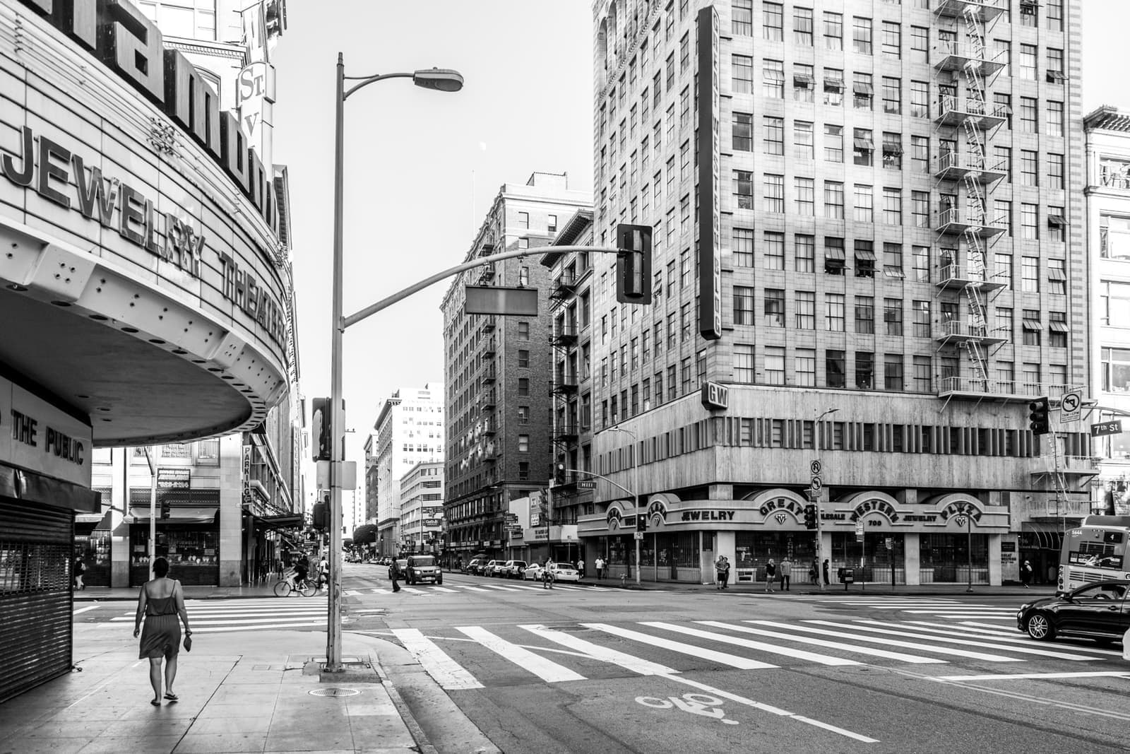 Black-and-white street corner with old towers and a theatre marquee