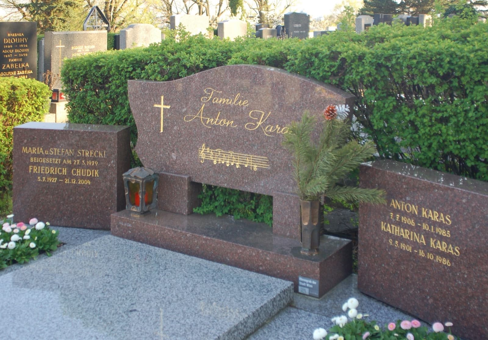 A granite family gravestone engraved with the words Anton Karas and bars of music
