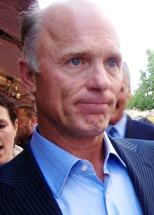 Ed Harris, close up, in a blue shirt and dark jacket