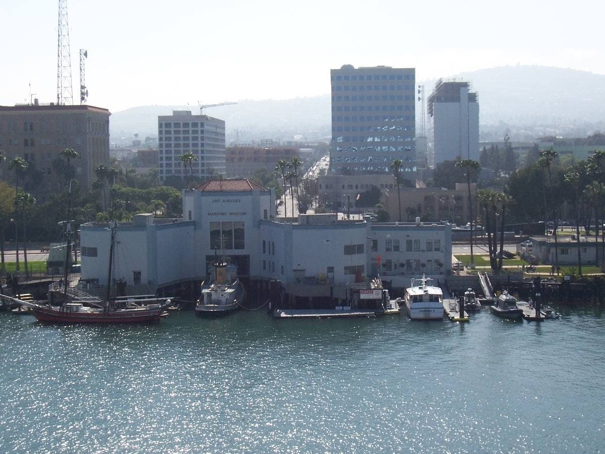 A white Streamline Moderne ferry building on the harbour water