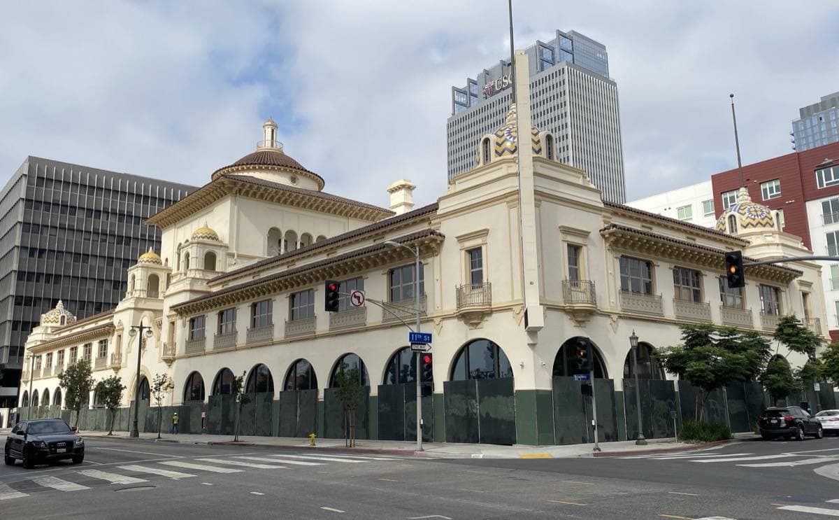 A Mission Revival building with tiled domes on a downtown corner
