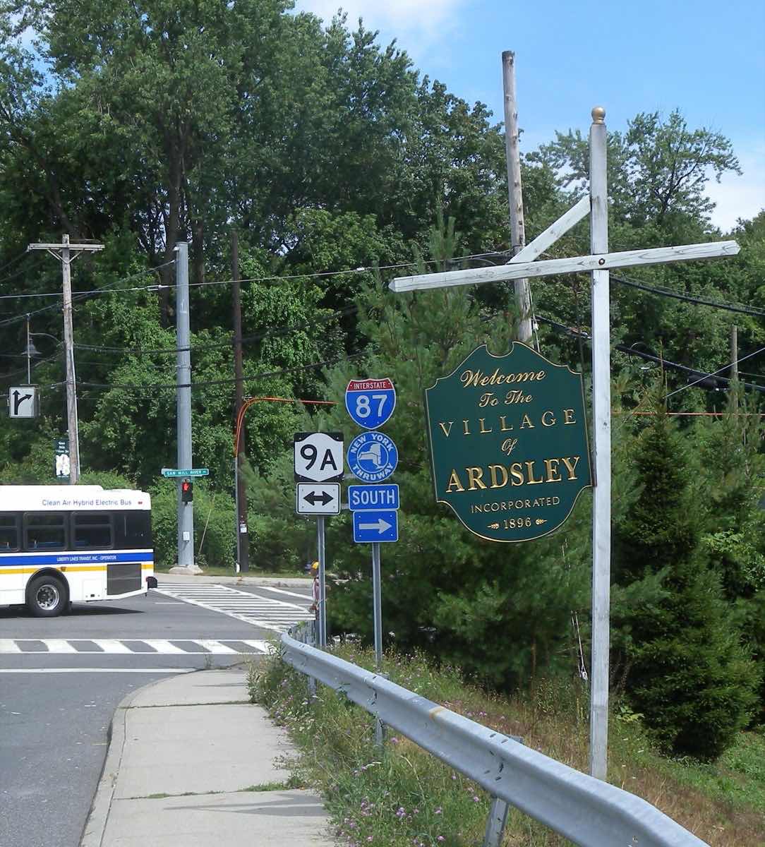 A green welcome-to-Ardsley sign beside a road