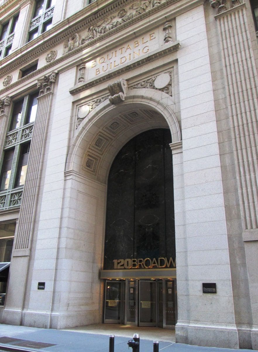 A tall arched stone entrance with revolving doors