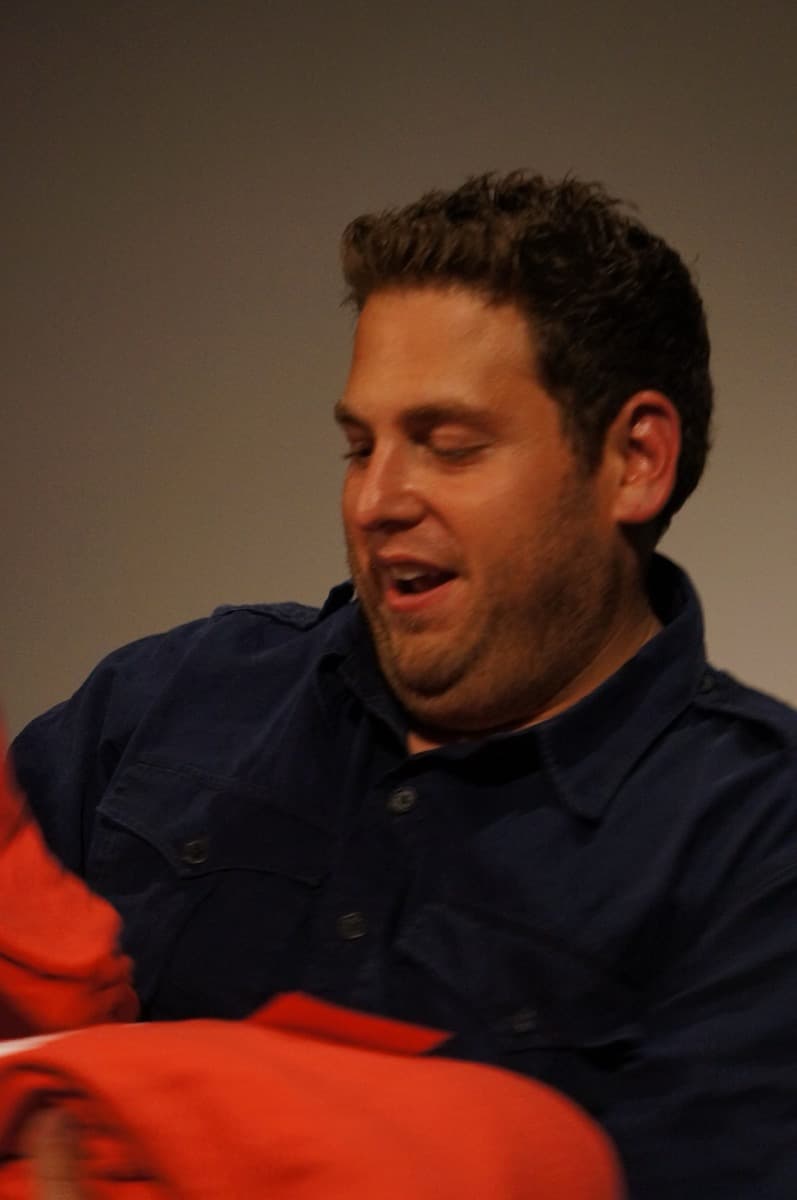 Jonah Hill in a dark navy shirt, smiling, at a screening