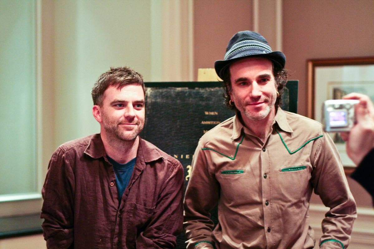 Paul Thomas Anderson and Daniel Day-Lewis standing side by side in a panelled room