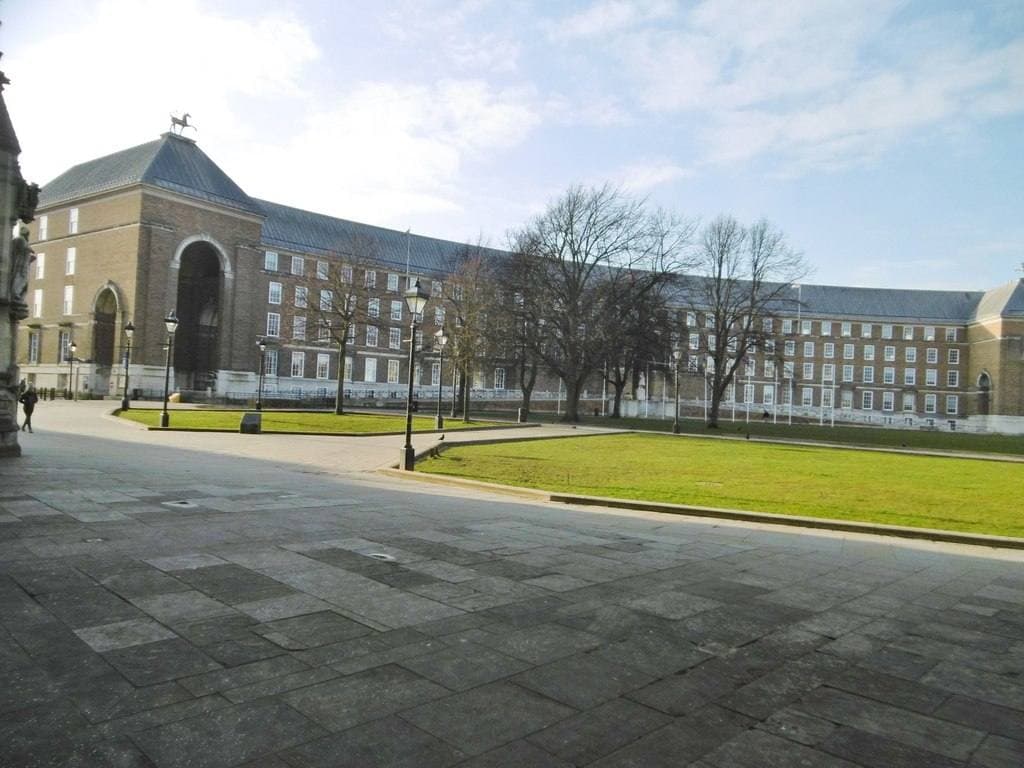 The long curved brick front of Bristol City Hall behind a lawn