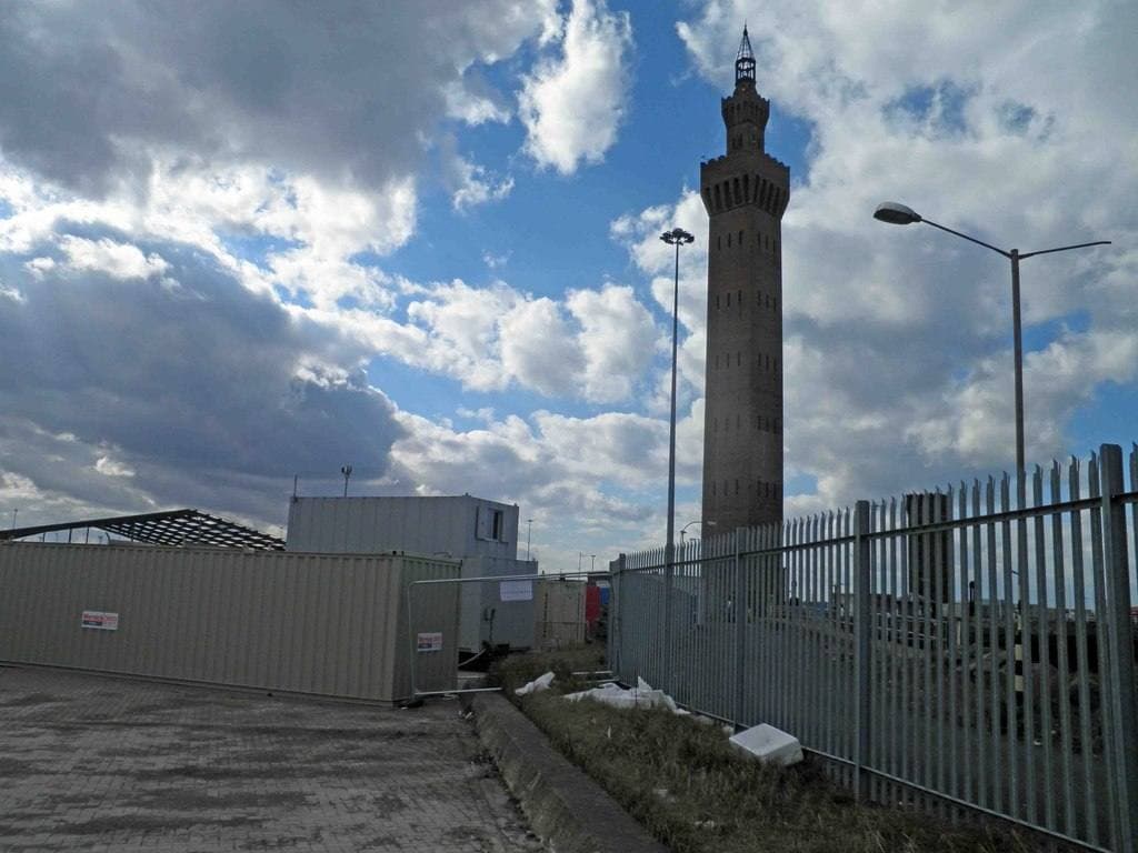 A tall brick tower behind palisade fencing on Grimsby docks