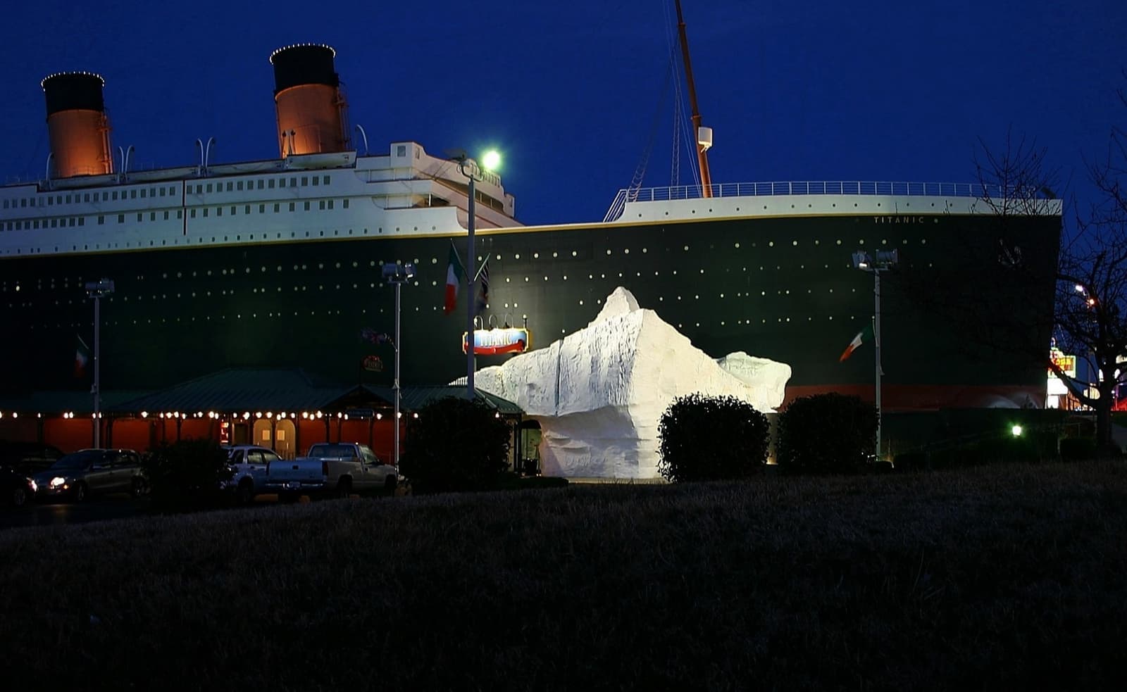 A lit half-ship building with funnels at night
