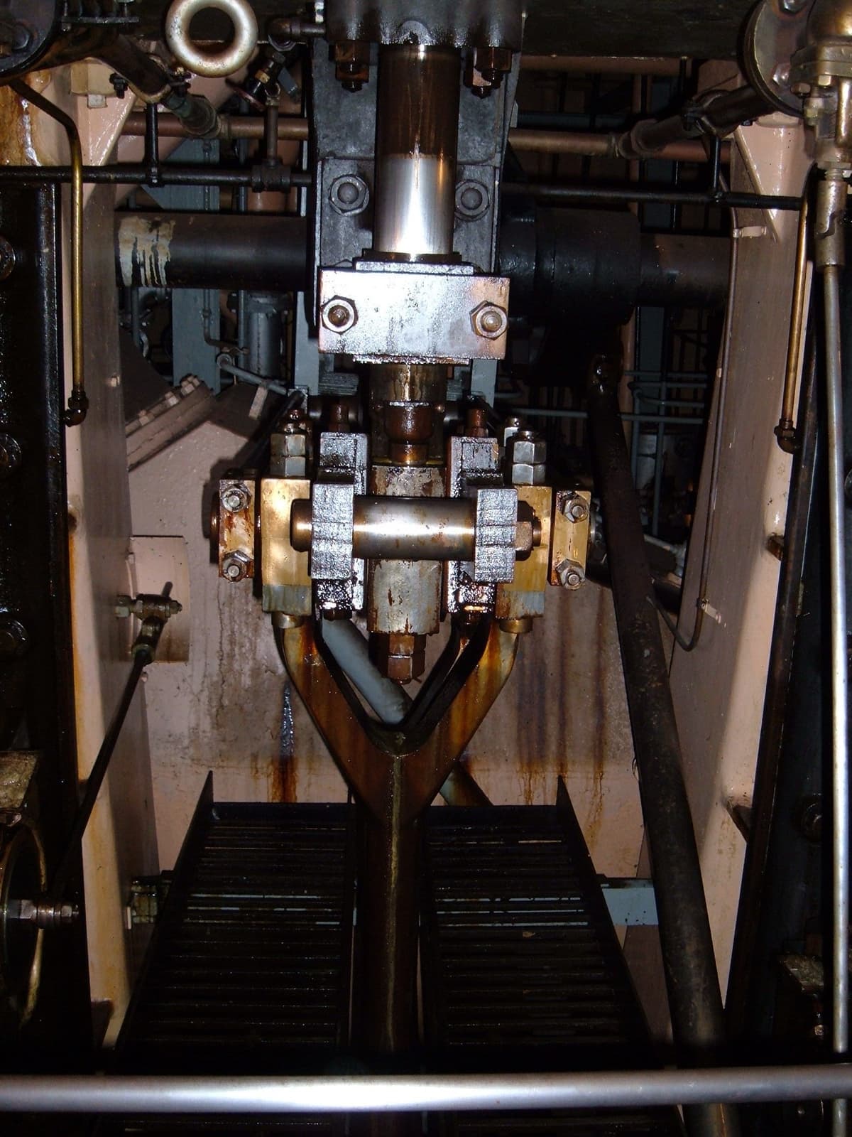 Looking down into a ship's engine room at steel pistons and rods