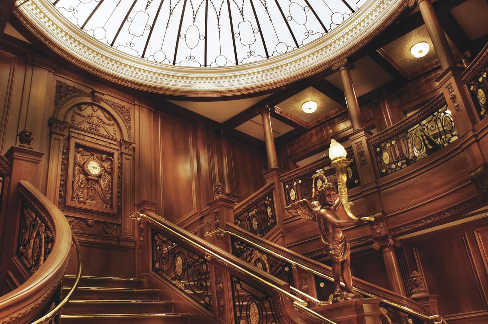 A carved oak staircase under a glass dome