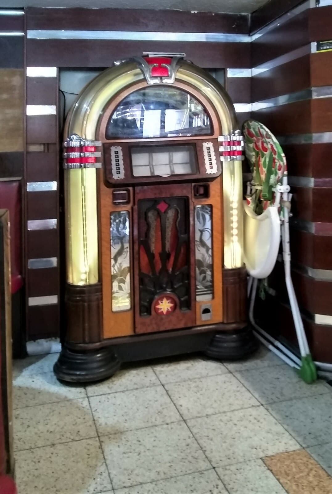 A lit vintage jukebox in a wood-panelled café corner