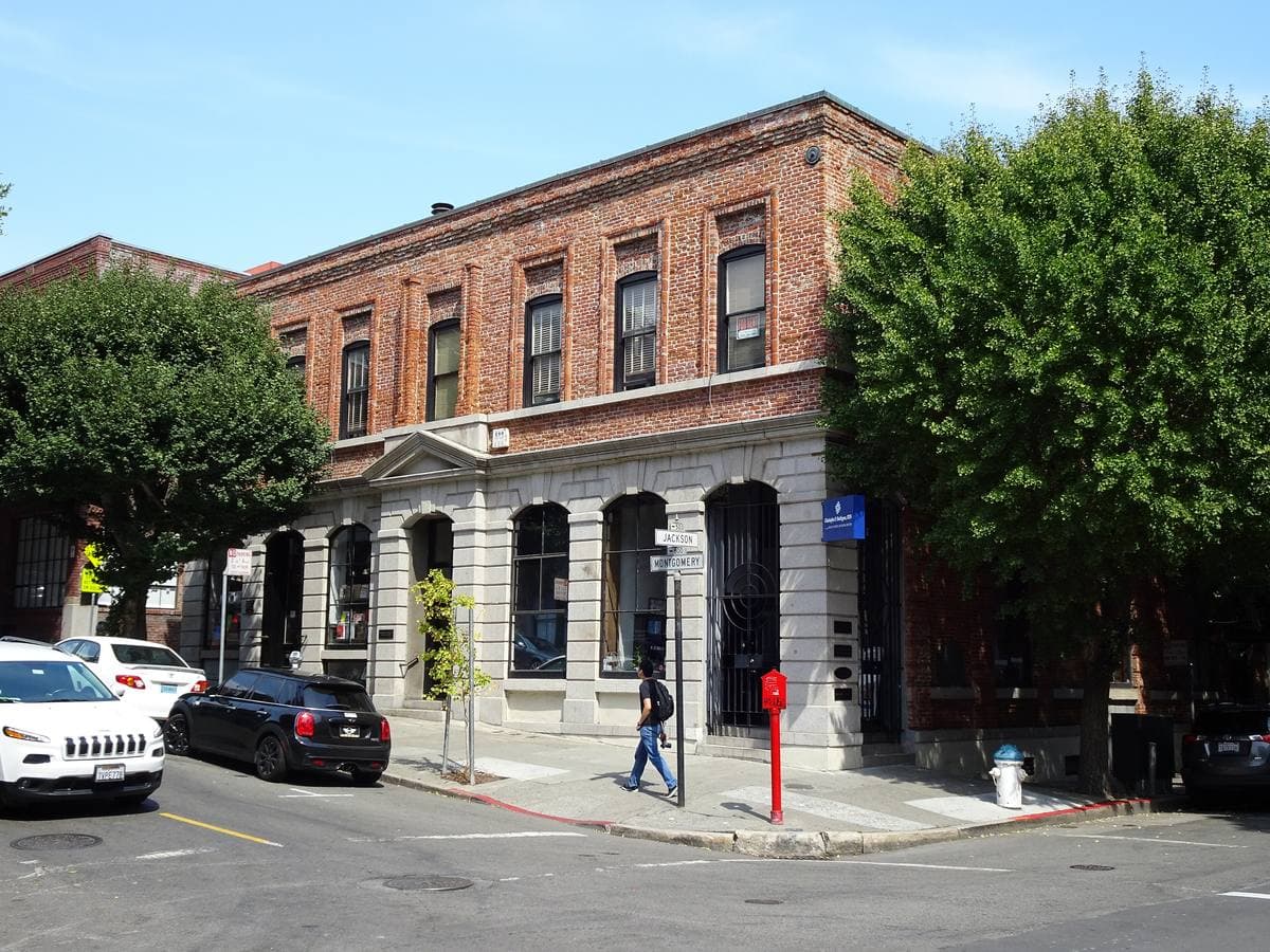 A two-storey brick and stone corner building on a quiet street