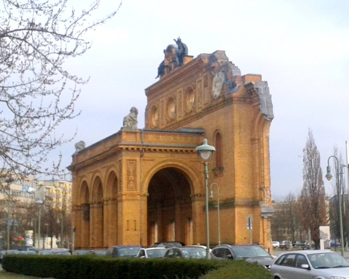 A ruined brick station façade with an arched entrance, standing alone