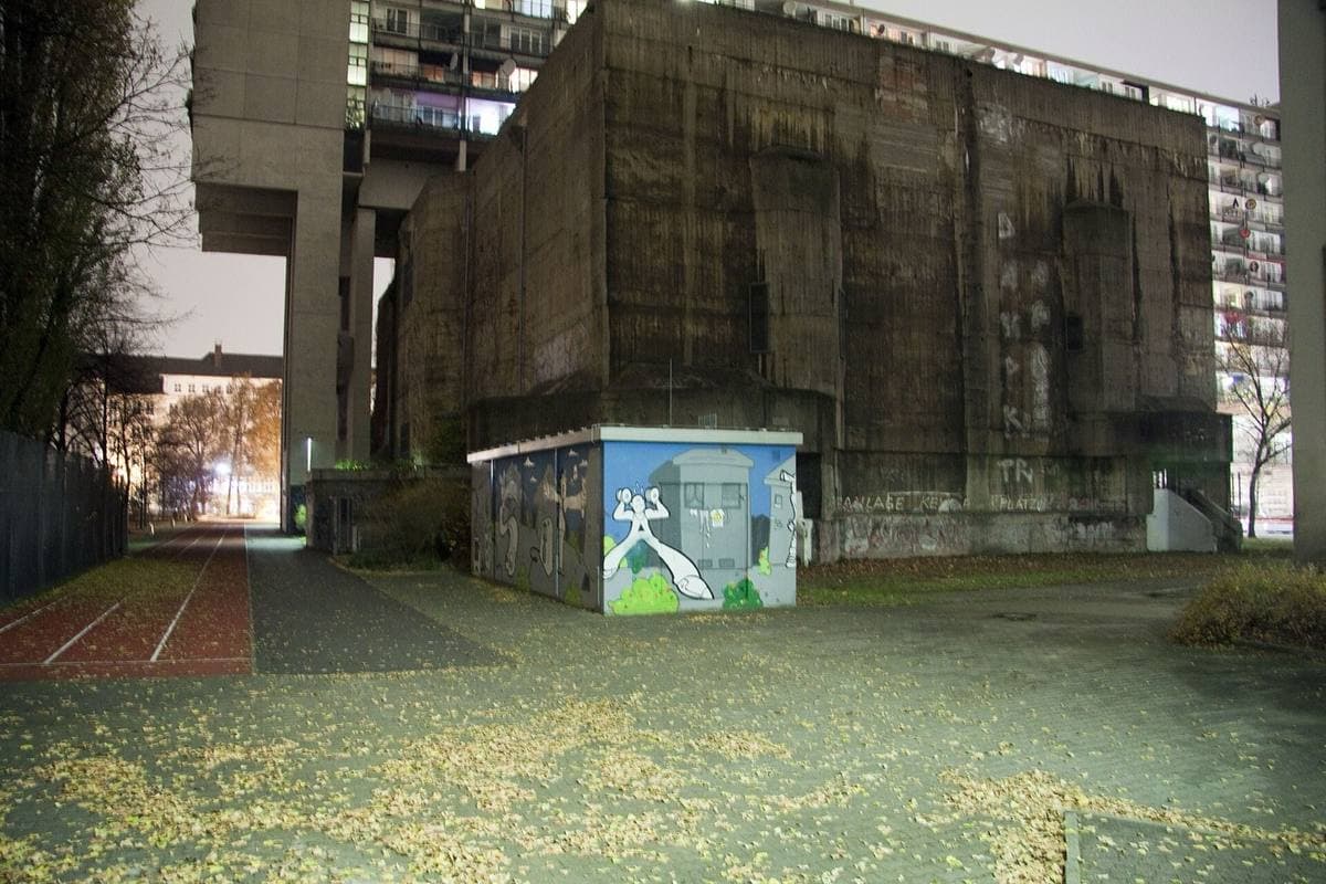 A massive concrete bunker beneath a housing block raised on columns