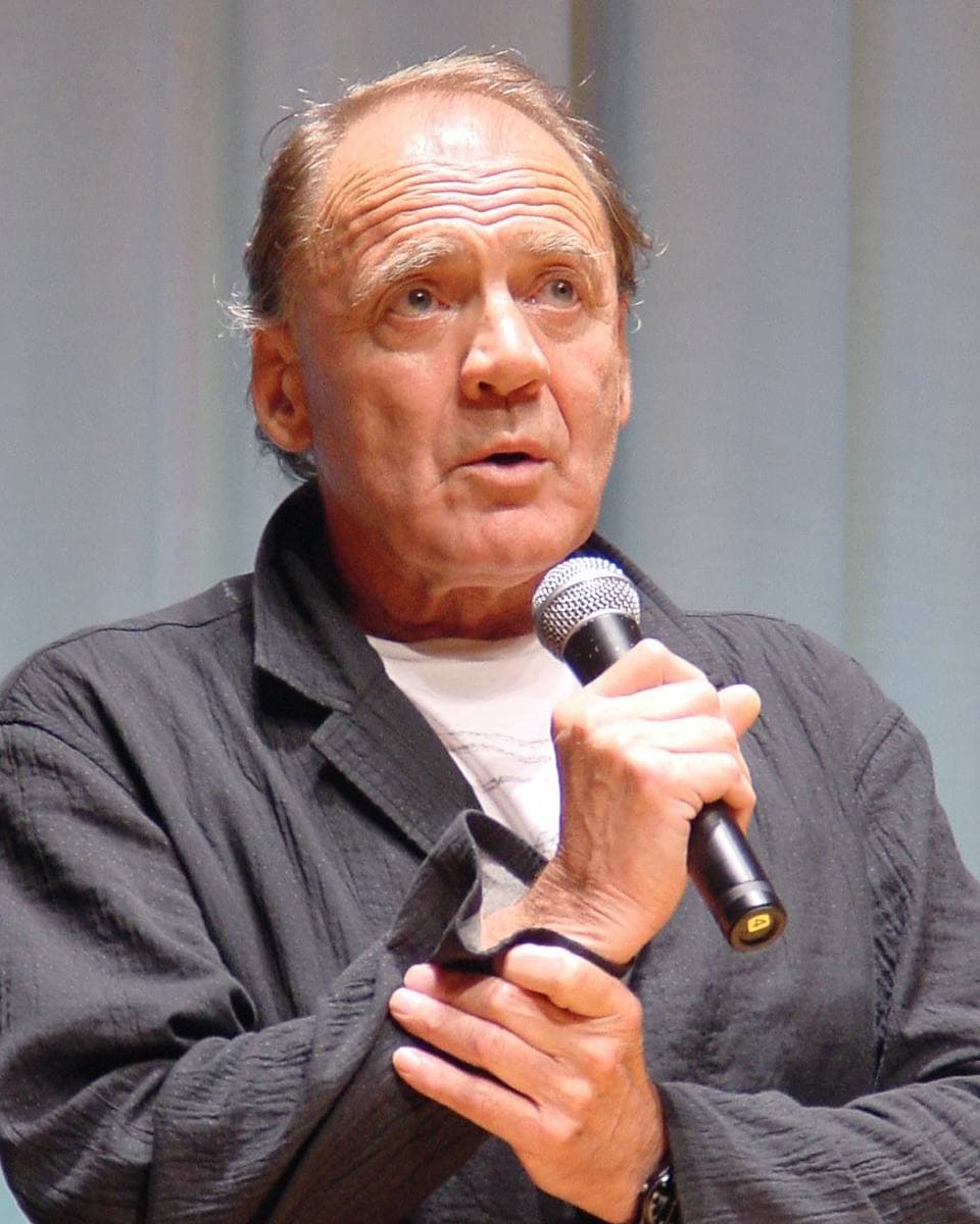 Bruno Ganz speaking into a microphone, his hand raised