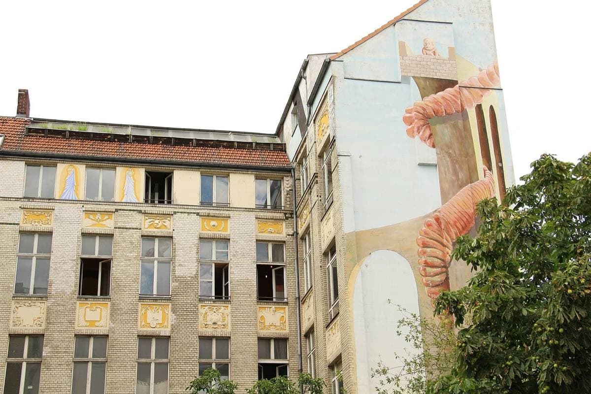 An old tenement with tall windows and a painted mural