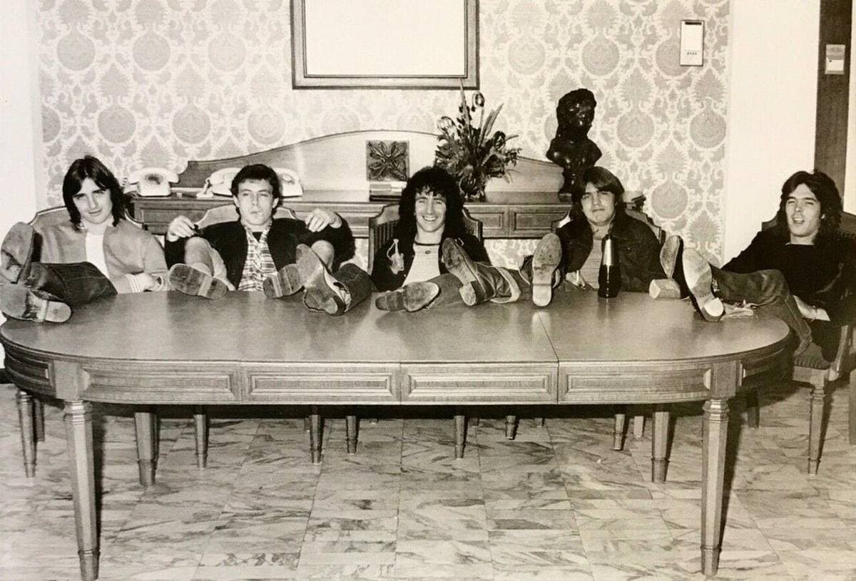 The five members of AC/DC in 1977 posed together, Bon Scott and Angus Young in front