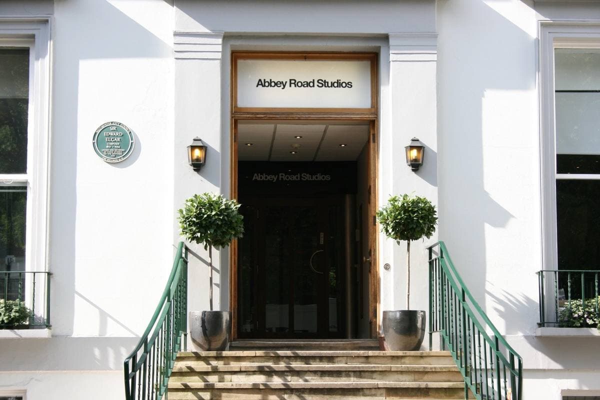 The white front of Abbey Road Studios with its name above the door between two clipped bay trees