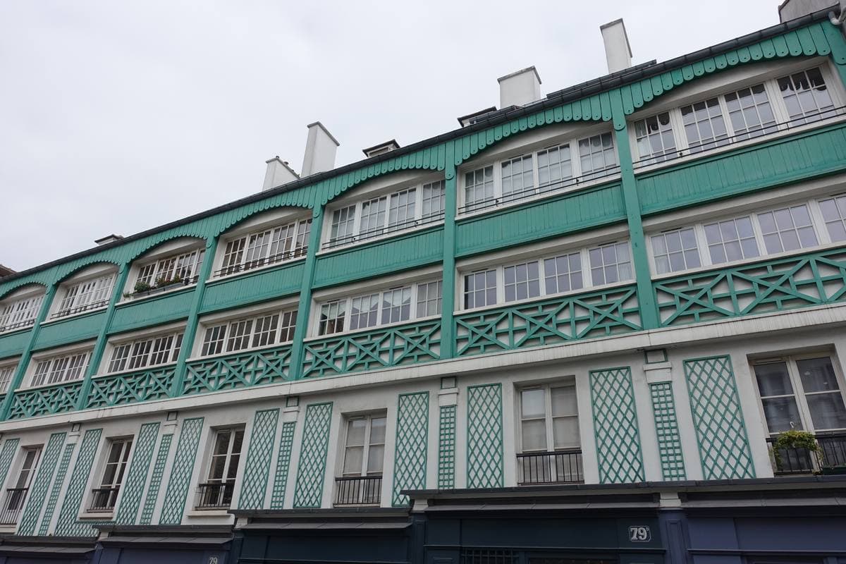 A cream Paris apartment building with balconies on a sloping Montmartre street