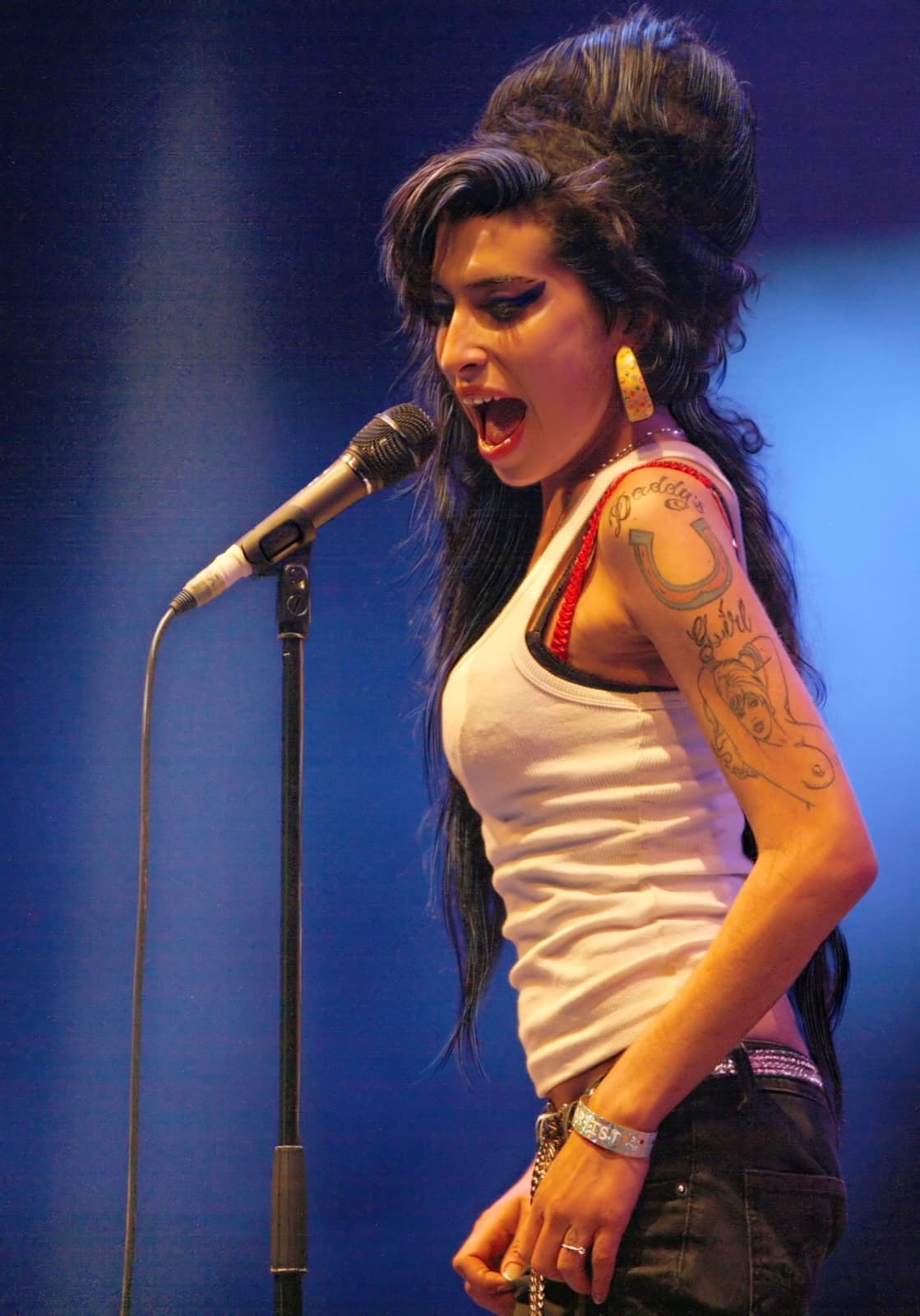 Amy Winehouse at the microphone with her beehive and winged eyeliner
