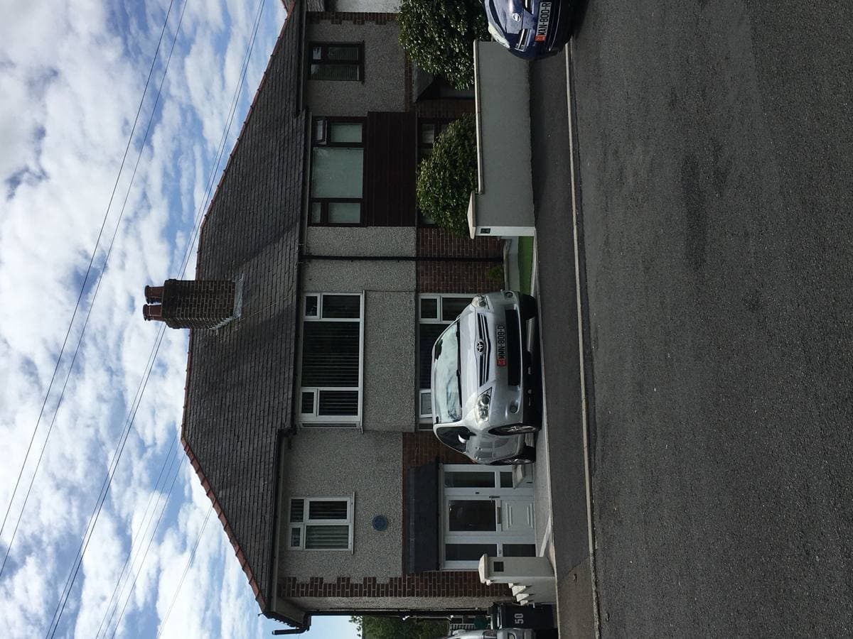 A pebble-dashed semi-detached house on a quiet road
