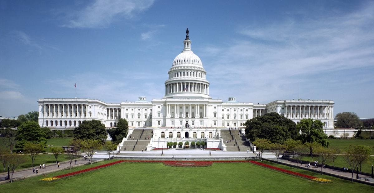 The white domed Capitol building above a wide green lawn