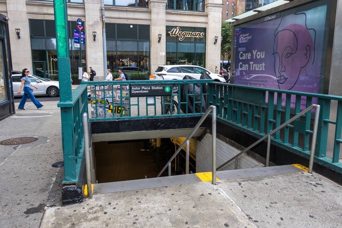 Green iron railings round a subway stair on a Manhattan pavement