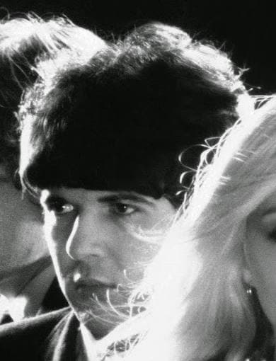Clem Burke as a young man with a dark mop-top, lit from the side against black