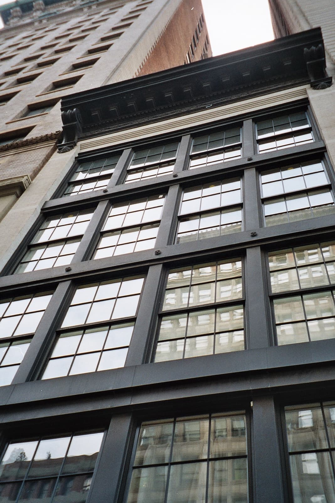 Looking up at a dark-framed loft building with tall windows on Park Avenue South