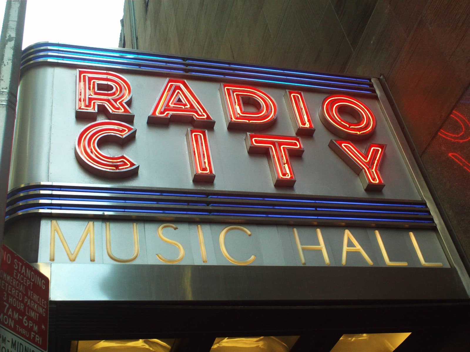 Red neon letters reading Radio City above Music Hall in gold, on a chrome sign