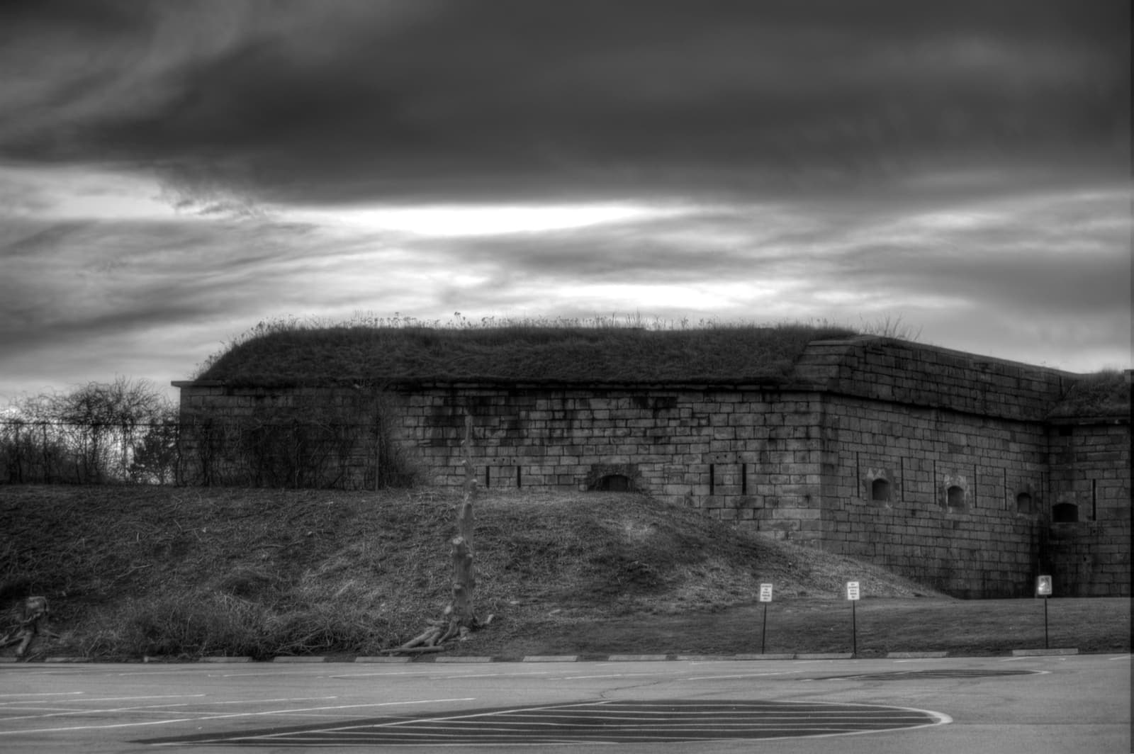The granite walls of a coastal fort on a grassy rise