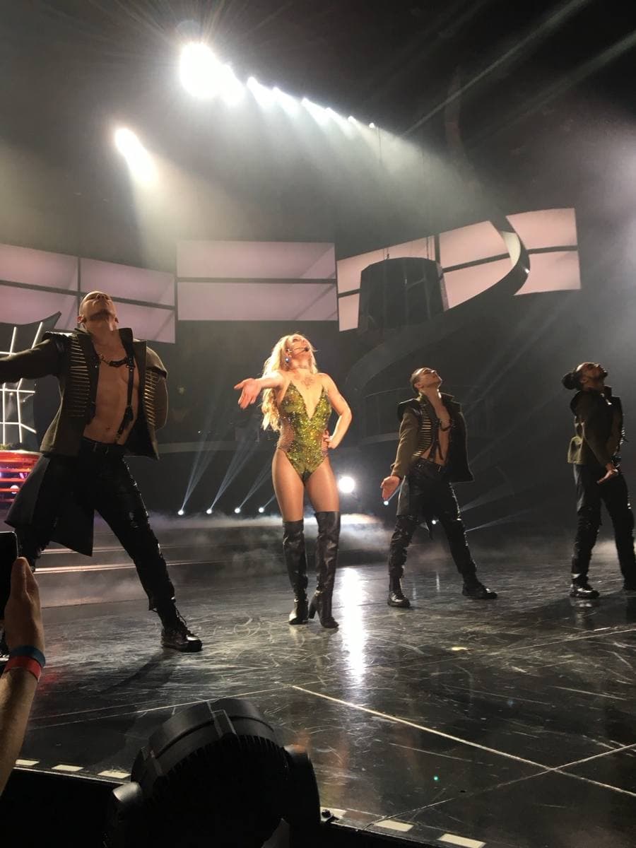 A singer under stage lights in a large Las Vegas theatre