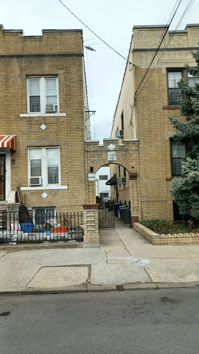 A row of brick and sided houses along a quiet Brooklyn street